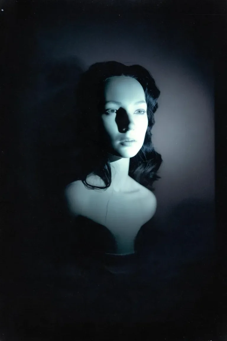 An AI generated image using Stable Diffusion depicting the bust of a mannequin with an ethereal, blue lighting illuminating its face amidst a dark, eerie background.