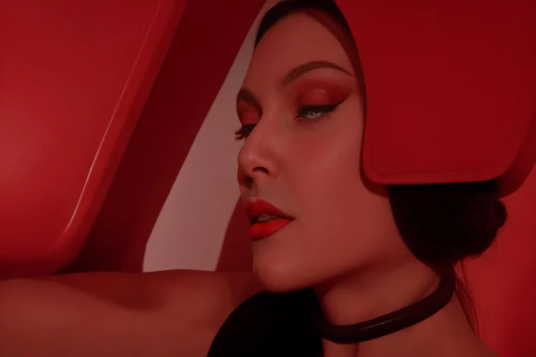 A close-up of a woman in a red futuristic outfit with matching red eye makeup and lipstick, AI generated using Stable Diffusion.