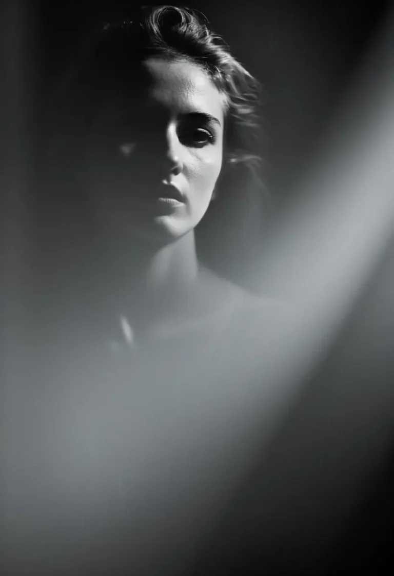 A dramatic black and white AI generated image using Stable Diffusion, featuring a woman's face partially illuminated with soft, diffused light.